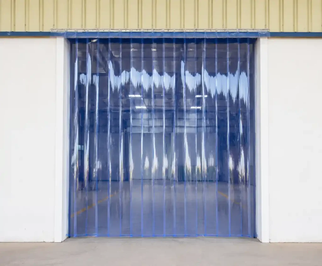 Blue transparent PVC strip curtain installed at warehouse entrance.