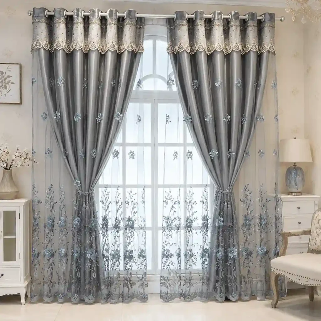 Grey layered sheer curtains with decorative embroidery for large windows.