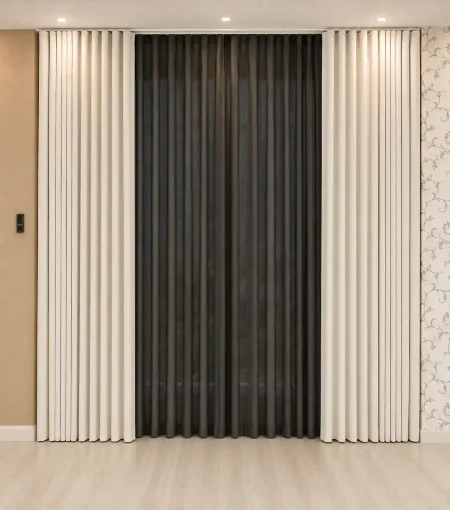 Dark charcoal curtains with a white sheer panel covering a wide window.