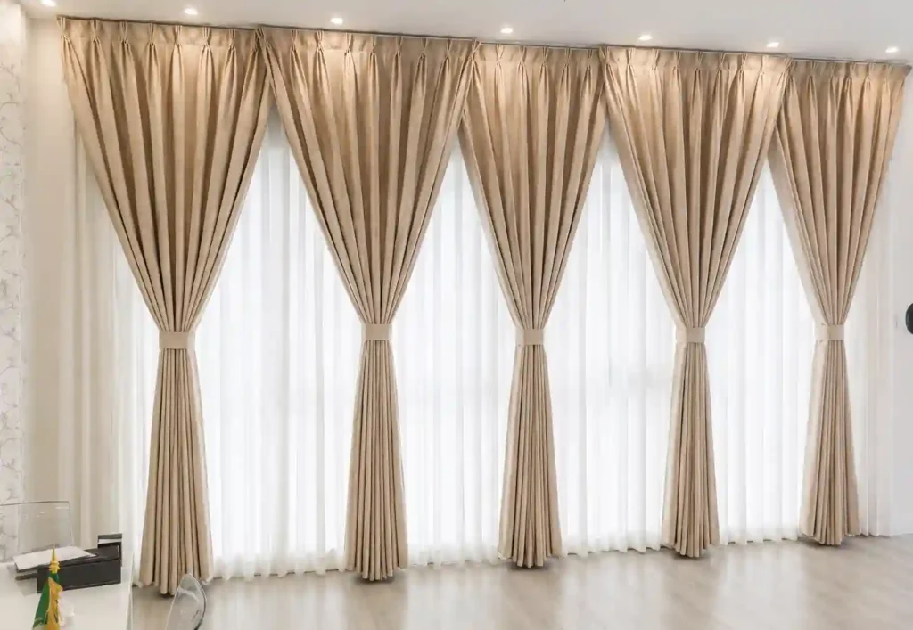 Classic beige pleated drapes installed across multiple tall windows.